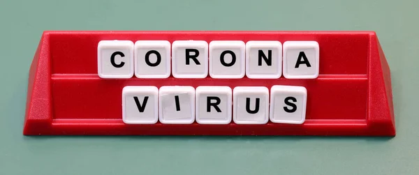 Coronavirus text made with plastic letters on a lectern during the board game
