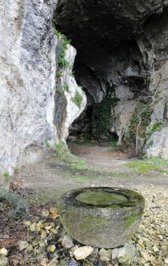 İlkel insanların yaşadığı bir mağaraya geniş bir giriş ve yağmur suyu toplamak için büyük bir havza.