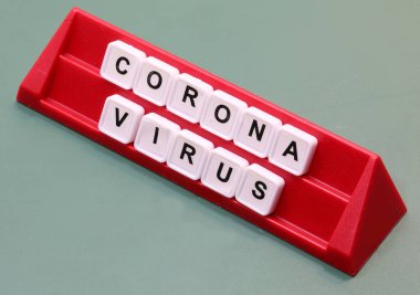 Coronavirus metni, masa oyunu sırasında kırmızı bir kürsüde plastik fayansların üzerindeki harflerle yazıldı