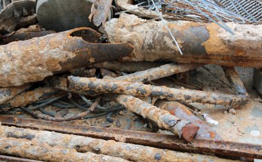 Demirden malzemelerin toplanması için çöplükteki eski paslı borular.