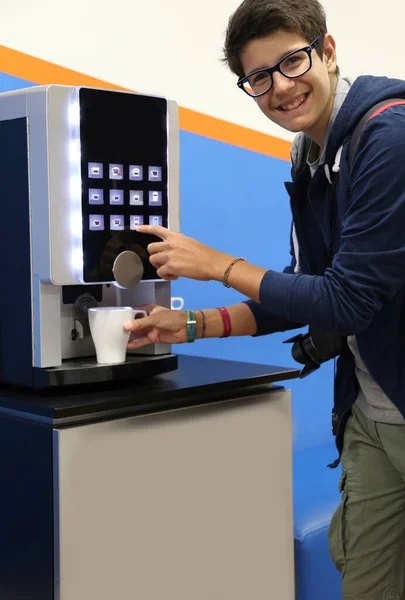 Very Happy boy drinks coffee at an hot beverage dispenser