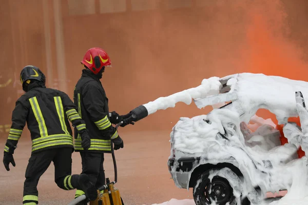 车祸后两名消防员用发泡剂扑灭了火势 — 图库照片