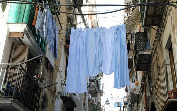 white clothes hung out to dry between the terraces of two houses