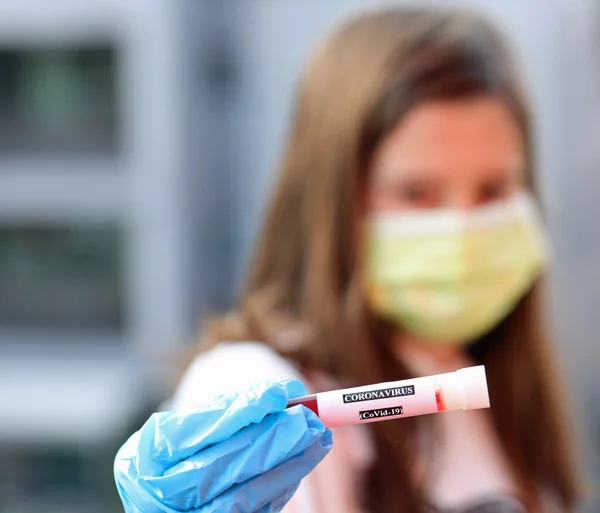 病院の感染症病棟で働いている間に外科マスクをつけていたCovid 19感染血液や若い看護師とも呼ばれるコロナウイルスのサンプル — ストック写真