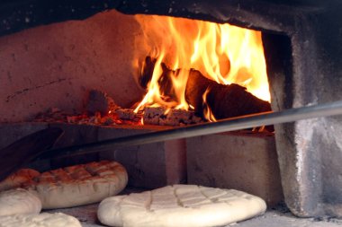 Eski bir ortaçağ ahşap fırınında yemek pişirirken somun ekmek
