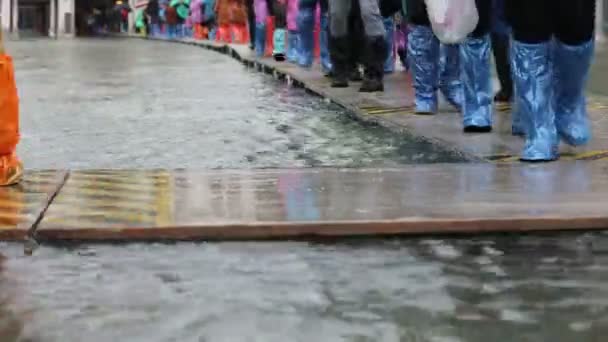 Wiele Osób Spacerujących Plastikowymi Gejterami Lub Butach Podczas Przypływu Wenecji — Wideo stockowe
