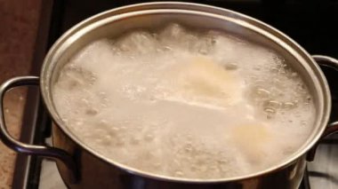Aşçı, mutfaktaki kaynar suda İtalyan makarnası ile tencerenin kapağını açar.
