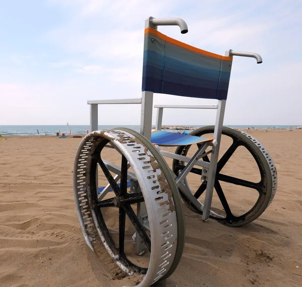 모래가 해변에서 수있는 커다란 바퀴가 휠체어 — 스톡 사진