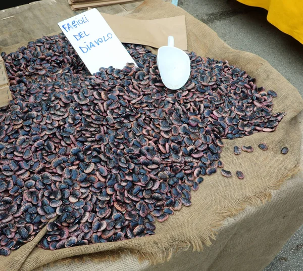 販売のための多くの特別な乾燥豆と彼らはスパイシーでおいしいので悪魔豆を意味するイタリア語のテキストとラベルで失速 — ストック写真