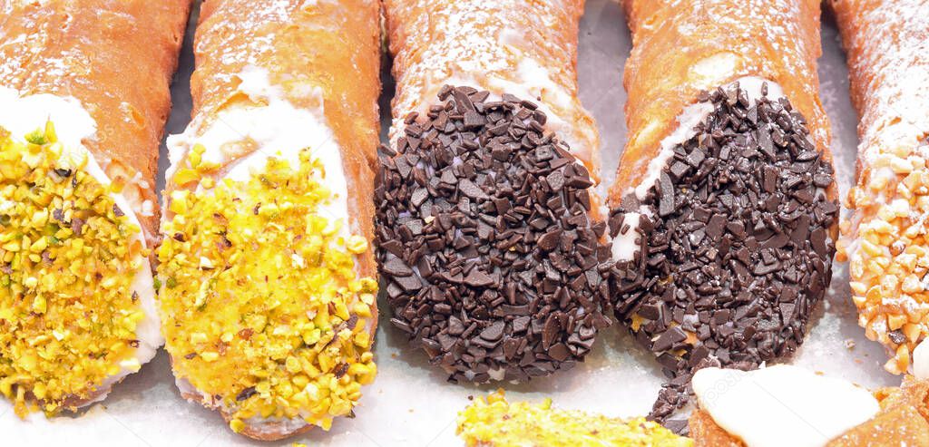 stuffed Sicilian cannoli with ricotta cheese chocolate and almonds for sale in the Italian pastry shop