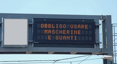 İtalya 'da yolda giderken Cerrahi Maske ve Eldiven Kullan anlamına gelen Metin içeren Bilgi Paneli
