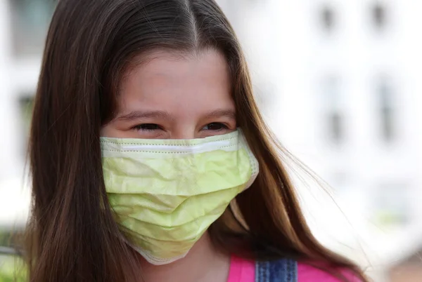 笑顔の目と致命的なウイルス冠から保護するための緑の外科マスクを持つ女の子 — ストック写真