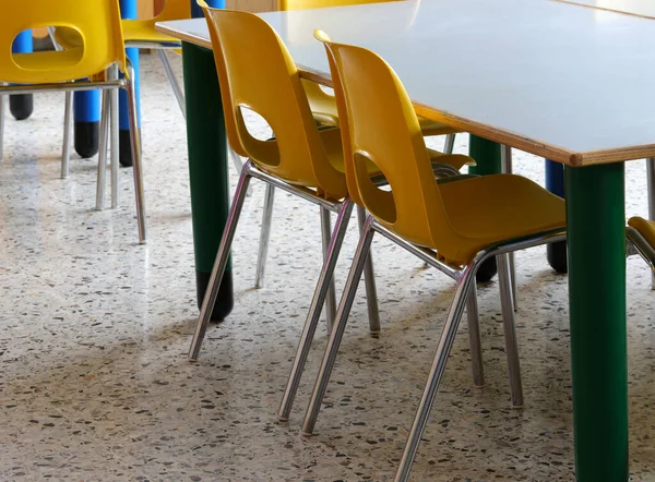 黄色の小さなプラスチック製の椅子の子供がいない小学校の教室の中で — ストック写真
