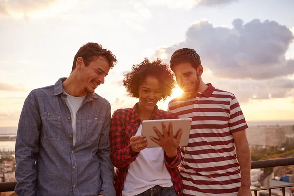 Trois amis heureux au coucher du soleil avec tablette — Photo