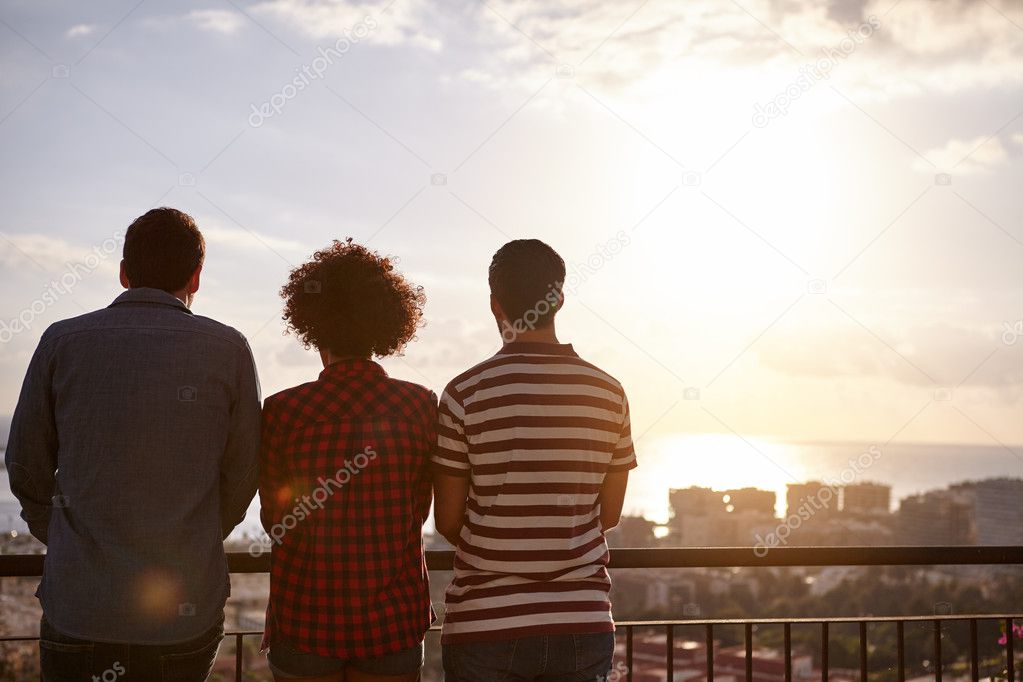 Three friends looking at sunset