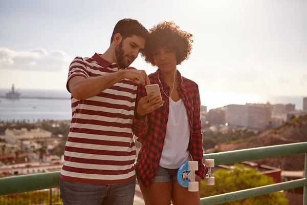 Молода пара з смартфоном на мосту — стокове фото