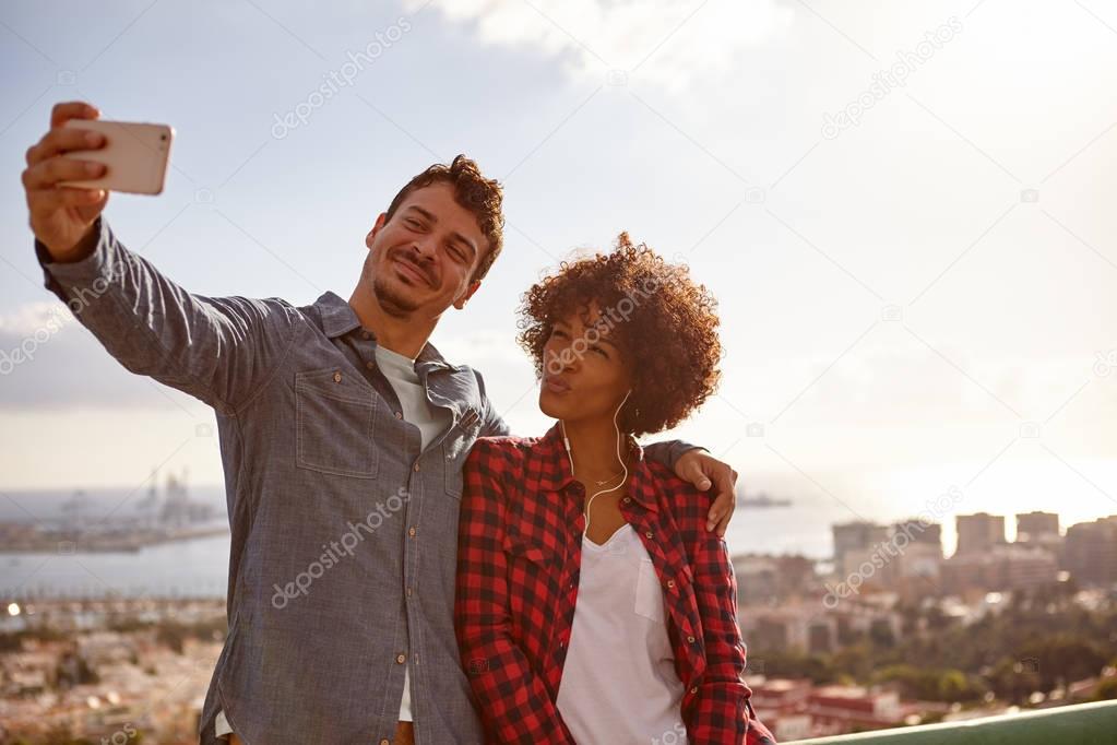 Happy young couple posing for selfie