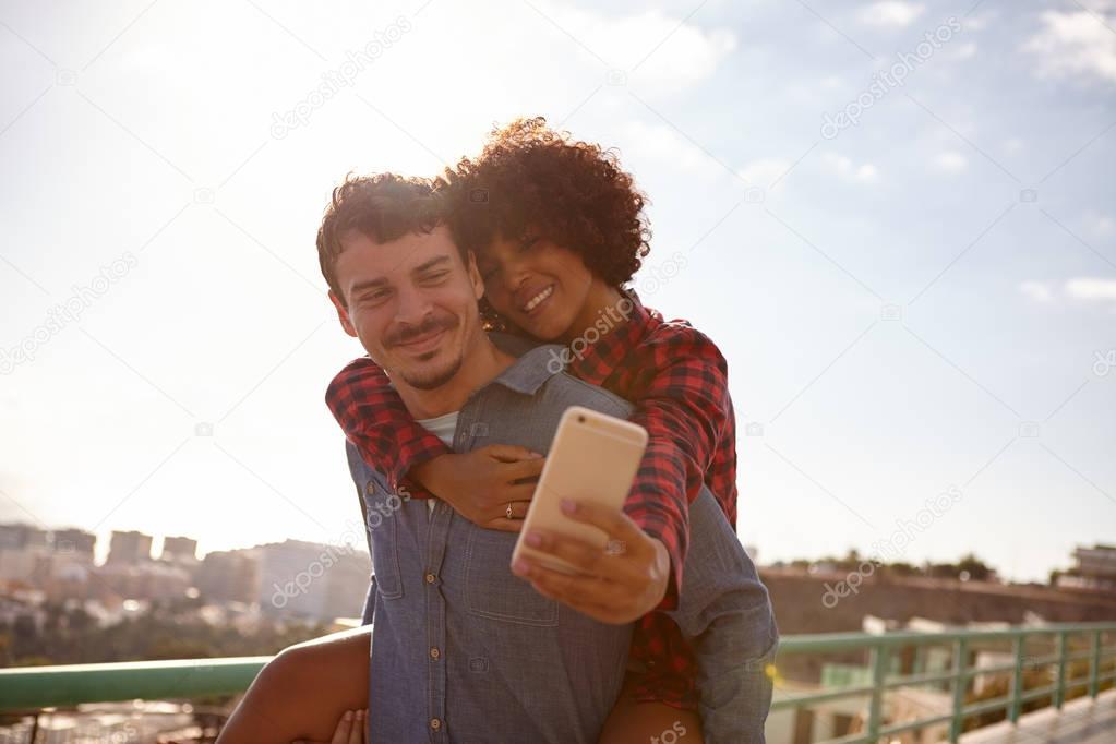 happy young couple taking selfie
