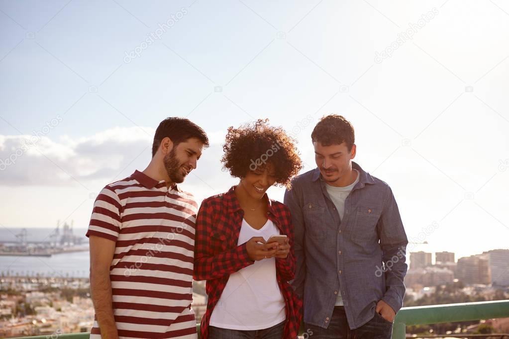 Two boys and girl with cell phone