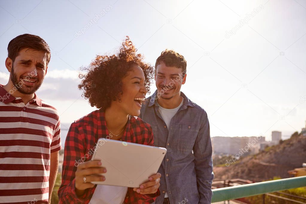 Three happy friends with digital tablet