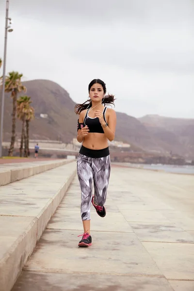 Young female running along beach — Stock Photo, Image