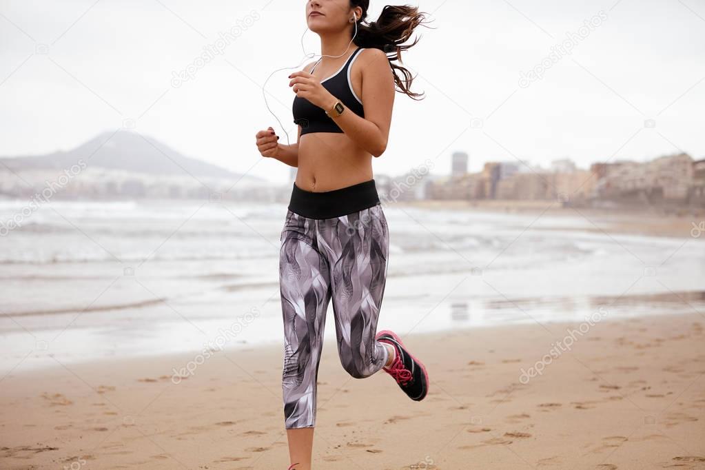 Young female running along beach