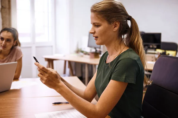 Junge Frau liest Nachricht auf Smartphone — Stockfoto