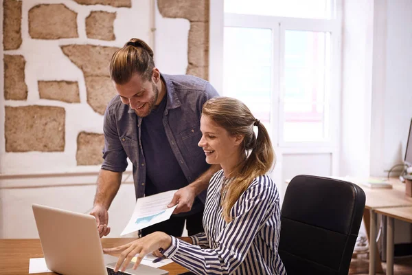 Skrattande ungt team tittar på laptop — Stockfoto