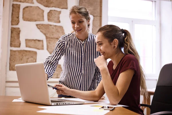 Unga affärskvinnor tittar på laptop — Stockfoto