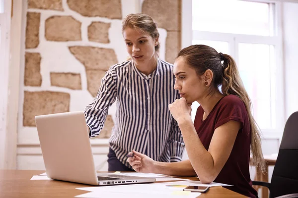 Unga affärskvinnor tittar på laptop — Stockfoto