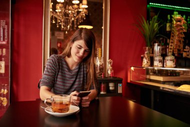 cep telefonu ile oturan genç kadın 