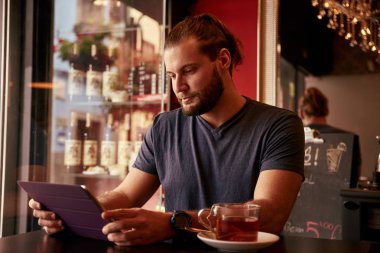 Tablet vasıl görünen genç adam  