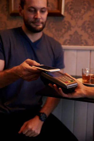 Mann benutzt Telefon, um Rechnung zu bezahlen — Stockfoto