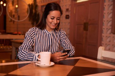 Akıllı telefon kullanan genç bir kadın. 