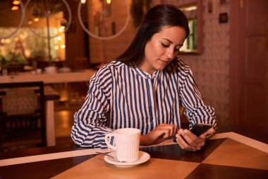 Akıllı telefon kullanan genç bir kadın. 