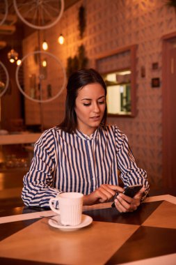 Akıllı telefon kullanan genç bir kadın. 