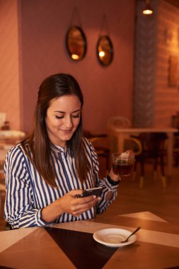 Akıllı telefon kullanan genç bir kadın.