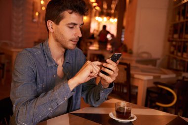 Genç adam akıllı telefon kullanıyor. 