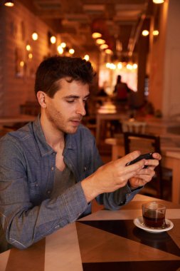 Genç adam akıllı telefon kullanıyor. 