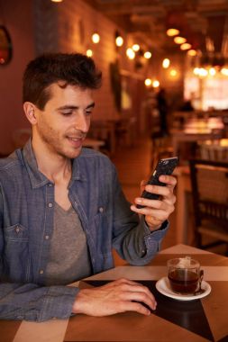 Genç adam akıllı telefon kullanıyor. 
