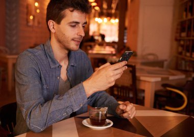 Genç adam akıllı telefon kullanıyor. 