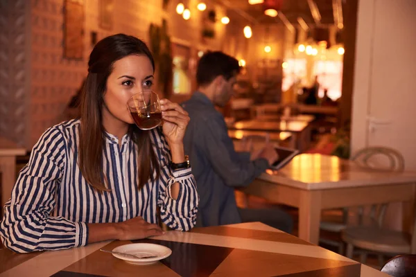 Молодая женщина сидит в ресторане — стоковое фото