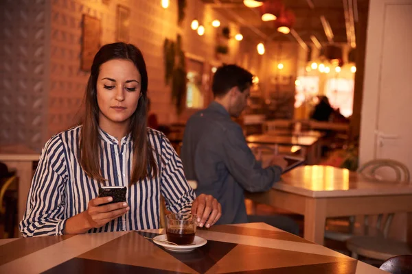 Smuk ung kvinde kigger på smartphone - Stock-foto