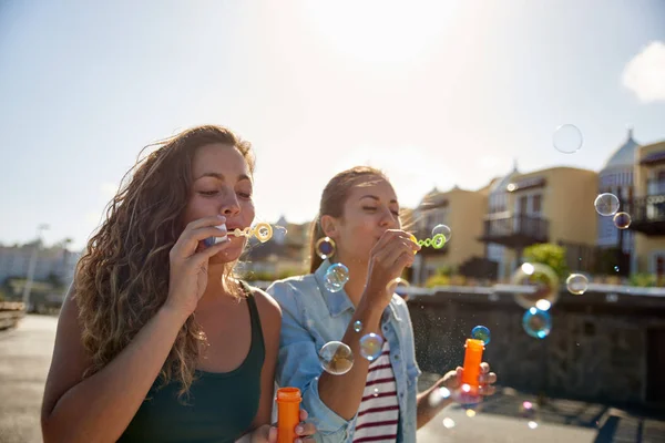 Due giovani donne che soffiano bolle — Foto Stock