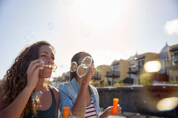 Due giovani donne che soffiano bolle — Foto Stock