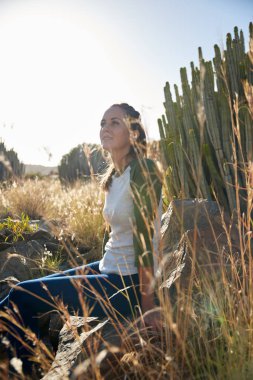 taş üzerine oturan genç kadın