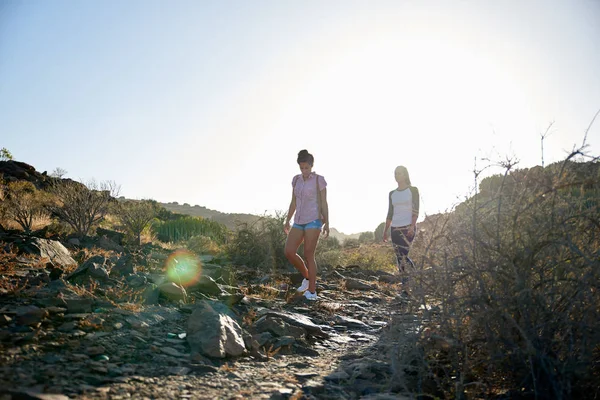 Mujeres jóvenes caminando en la colina rocosa — Foto de Stock