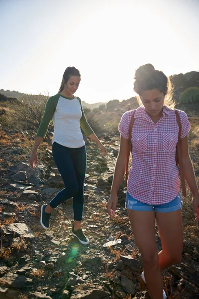 Mujeres jóvenes caminando en la colina rocosa — Foto de Stock
