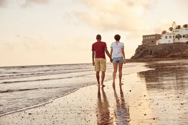 Couple strolling through breaking waves — Stock Photo, Image