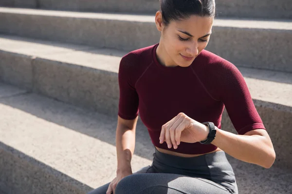 Young woman looking at watch